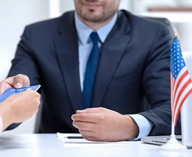 American consular officer giving passport to female immigrant, refugee visa