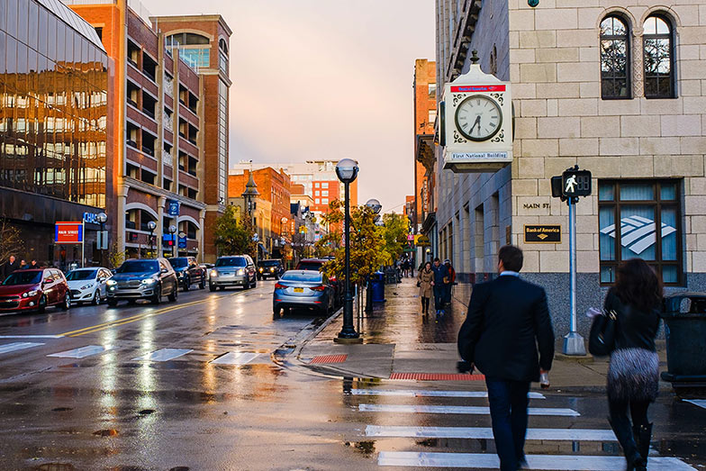 two people from behind crossing a street