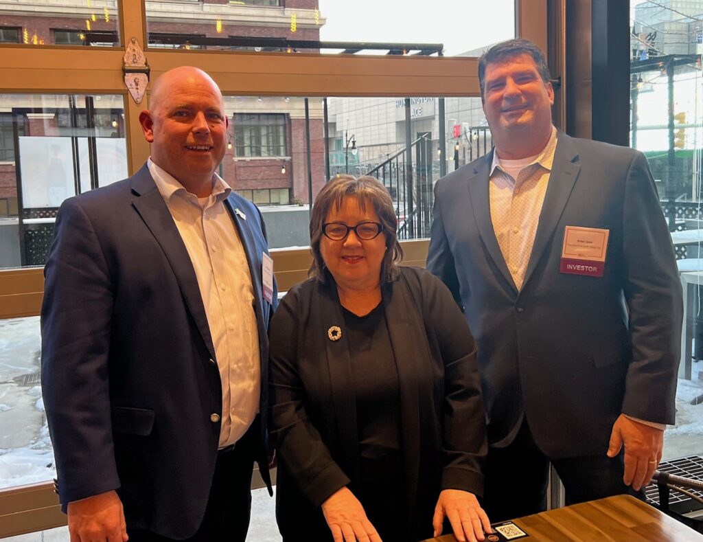Two men and a woman posing for a photo together