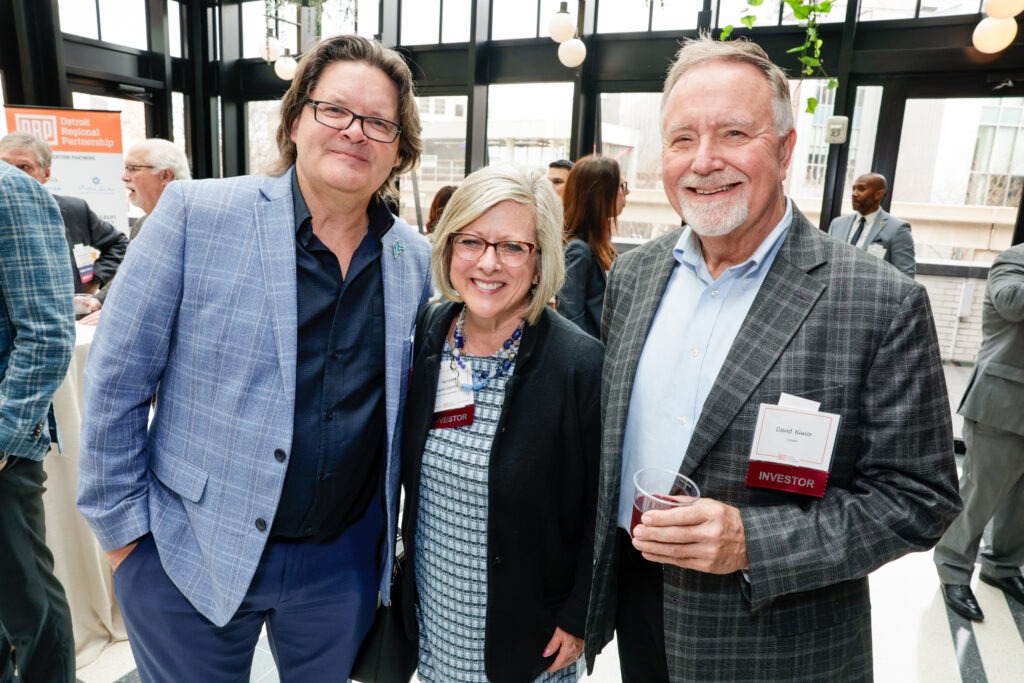 Three people standing side by side smiling