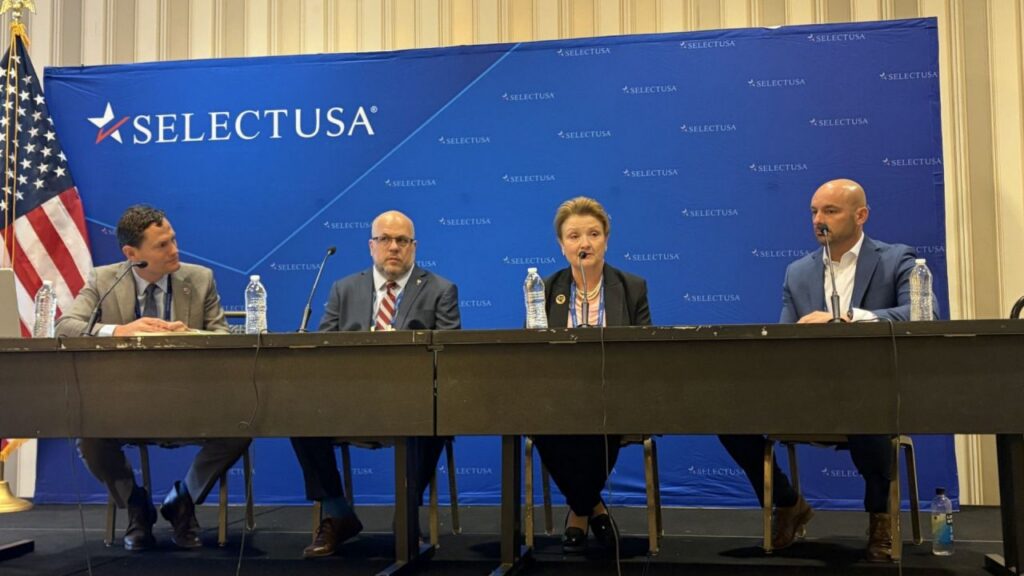 Four people sitting at a table giving a panel talk