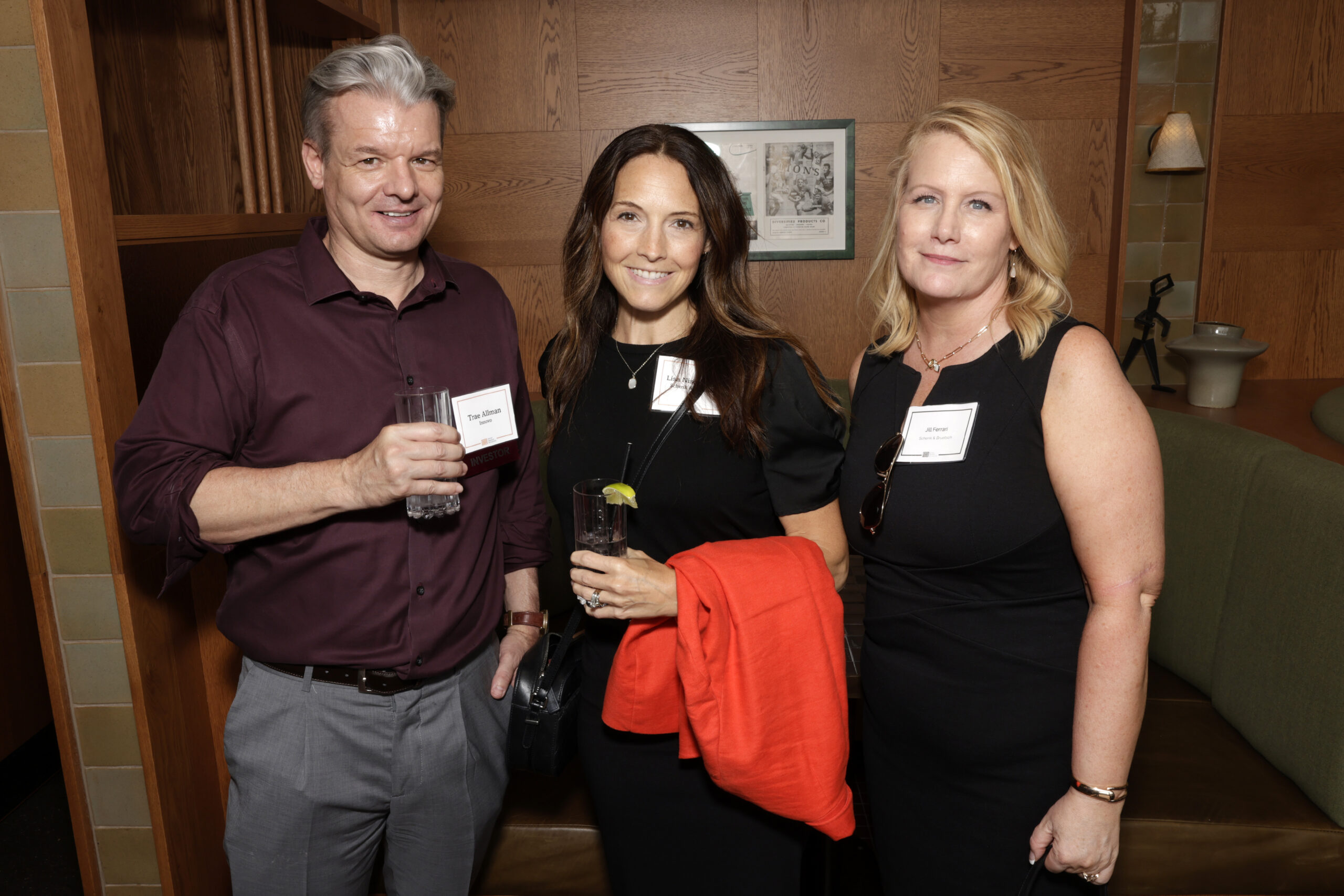 Three people standing together at a networking event