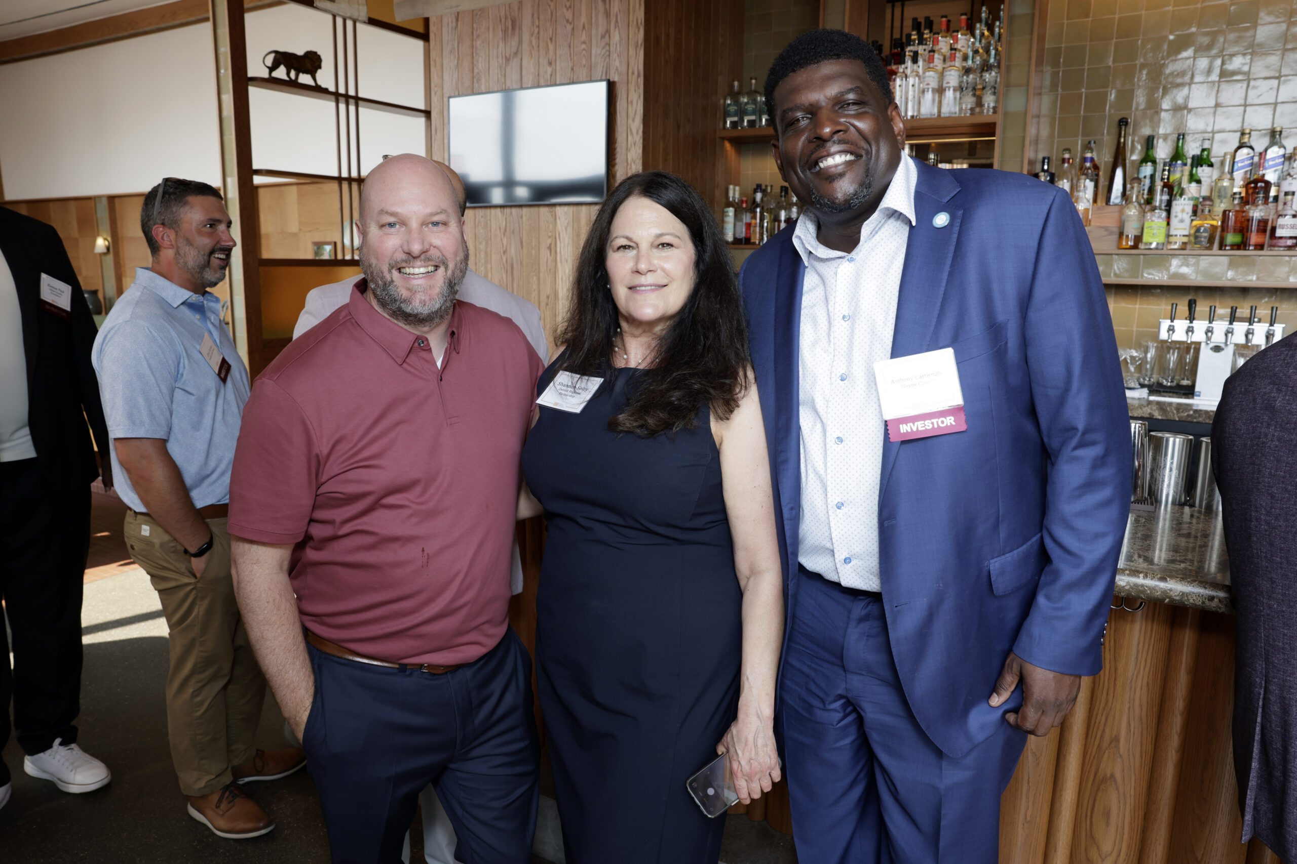 Three people standing together at a networking event