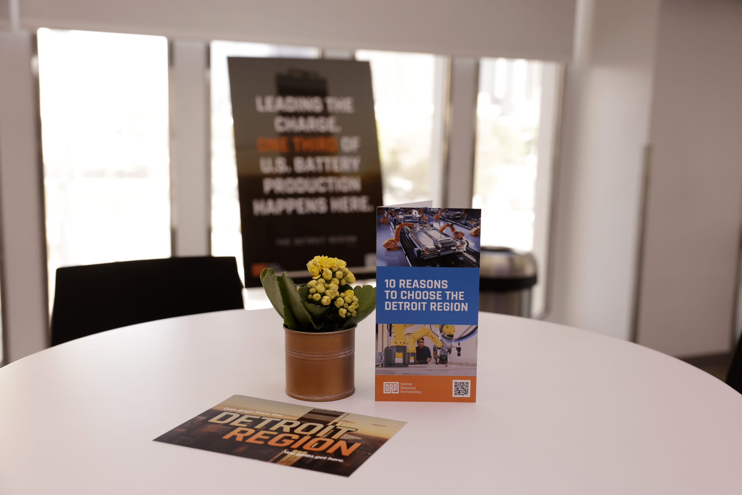 Table with a brochure, postcard, and flower arrangement